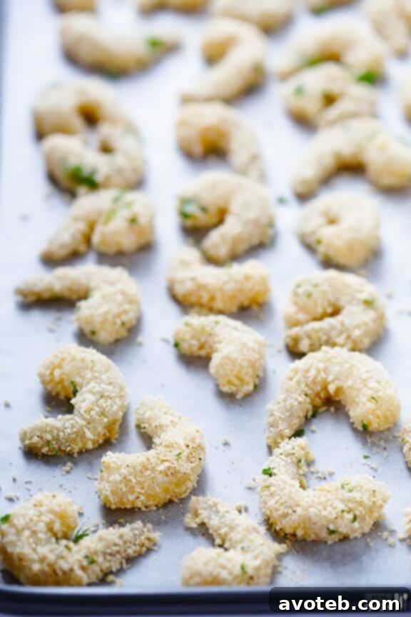 A baking sheet filled with perfectly coated shrimp, ready for the oven to transform into crispy baked popcorn shrimp.