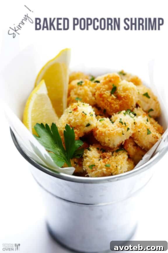 Served with fresh lemon wedges and parsley, a plate of golden-brown baked popcorn shrimp ready to be enjoyed with dipping sauce.