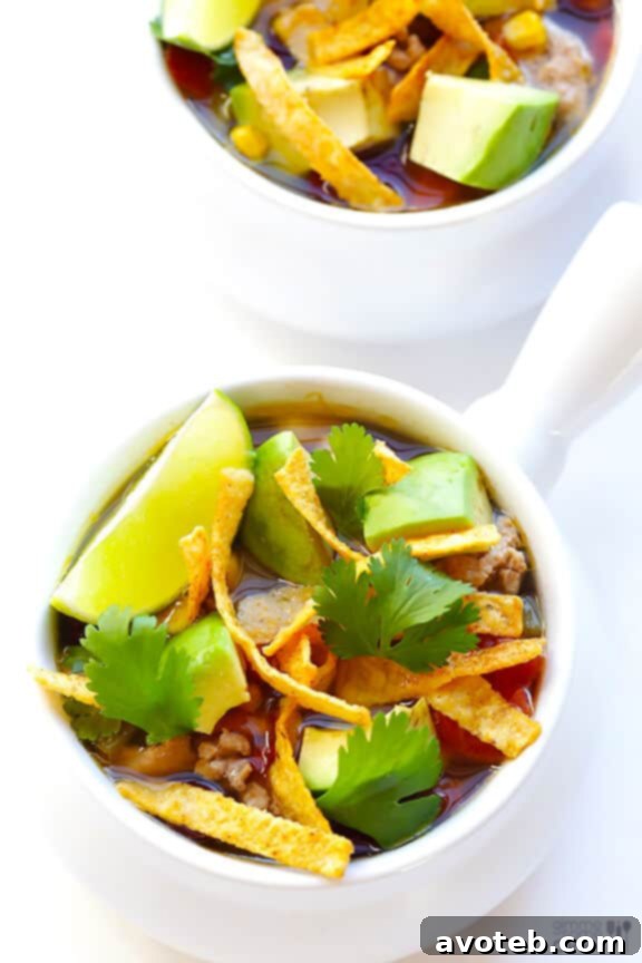 Final plated shot of Skinny Slow Cooker Taco Soup with various toppings, ready to serve.