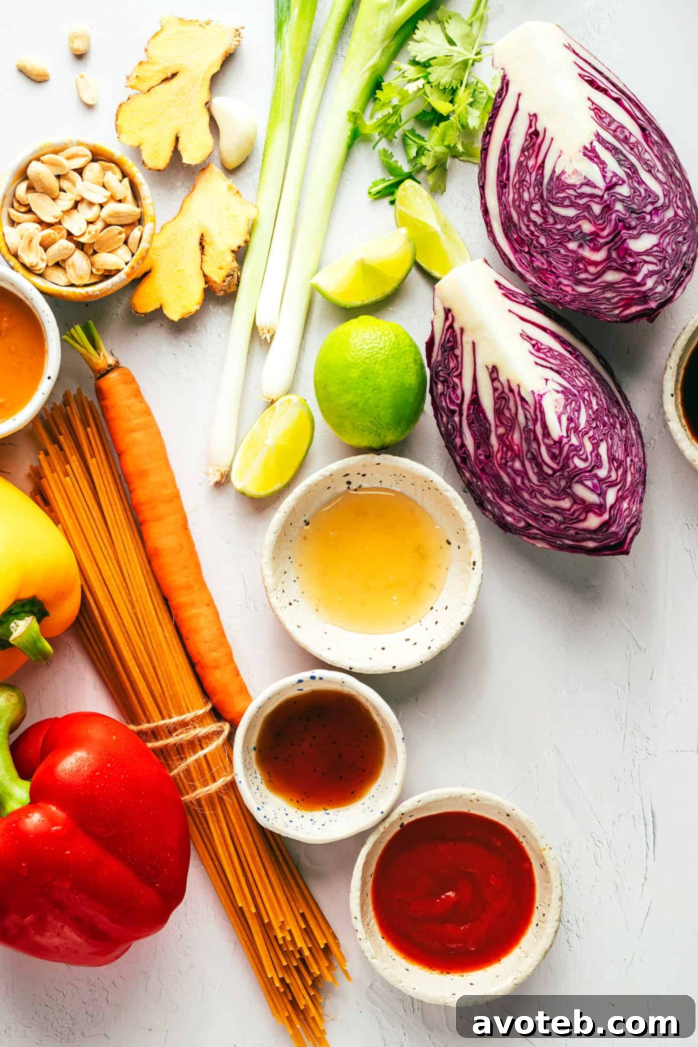 This rainbow peanut noodles recipe is made with colorful fresh veggies, your choice of noodles, and the most irresistible sesame-lime peanut sauce. Feel free to add in a protein (chicken, shrimp, beef, tofu, etc), serve warm or cold, and use whatever colorful vegetables you have on hand. Perfect for easy meal prep too! | gimmesomeoven.com Ingredients for Rainbow Peanut Noodles displayed on a cutting board