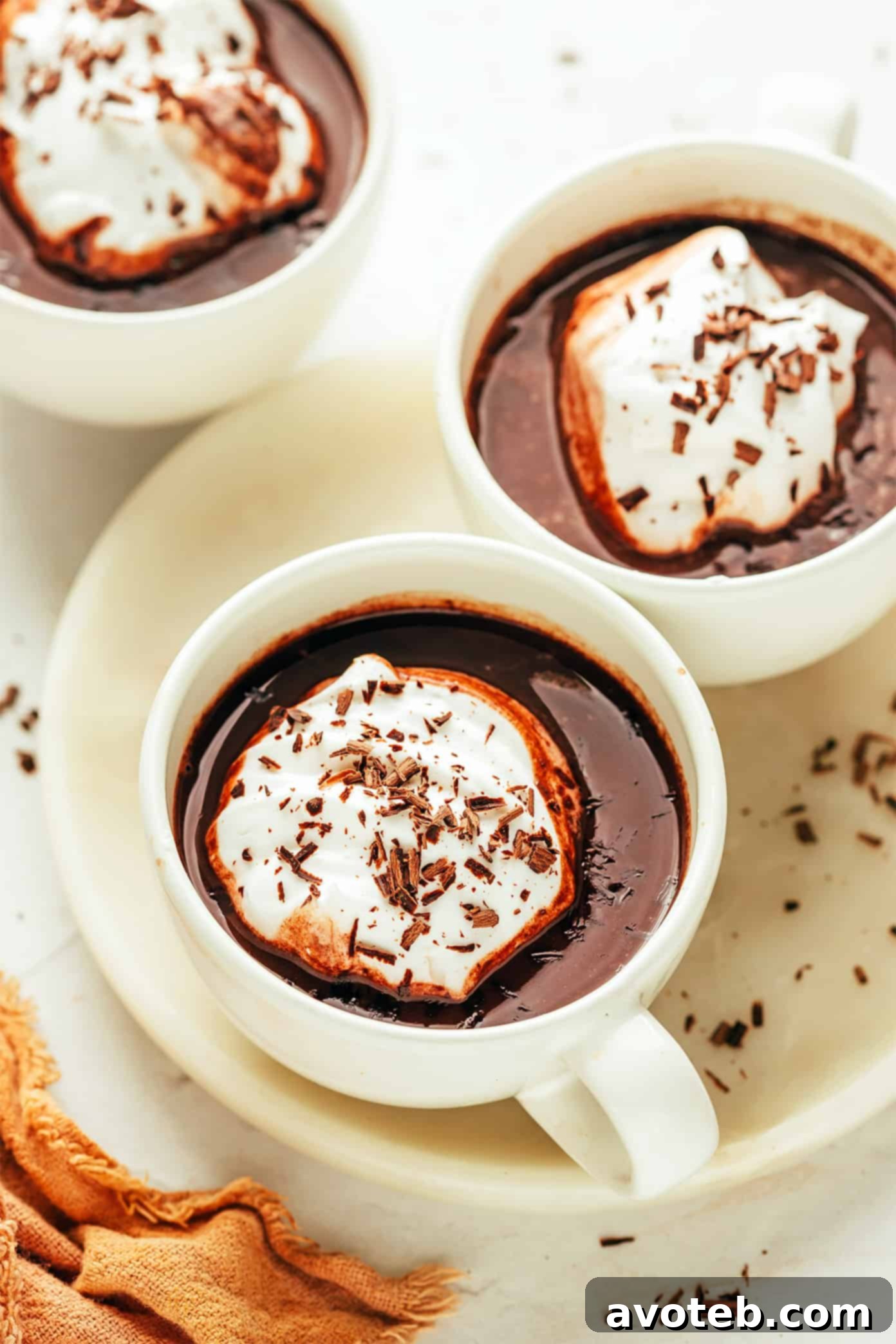 Velvet Cocoa 5 Several mugs of homemade hot chocolate with various toppings like whipped cream, marshmallows, and chocolate shavings.
