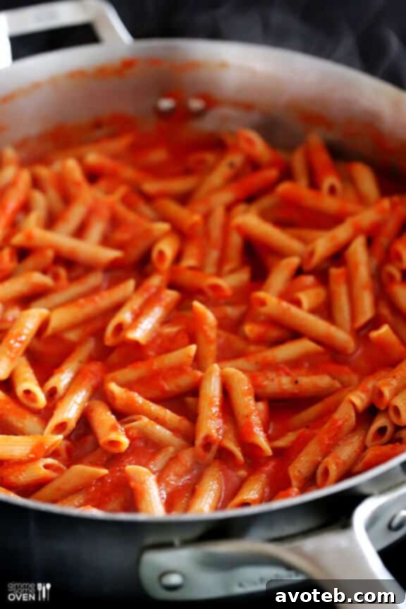 A serving of roasted red pepper pasta in a bowl.