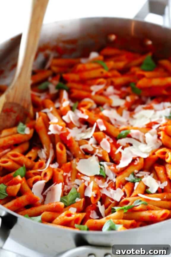 Pasta with roasted red pepper sauce topped with Parmesan and basil.