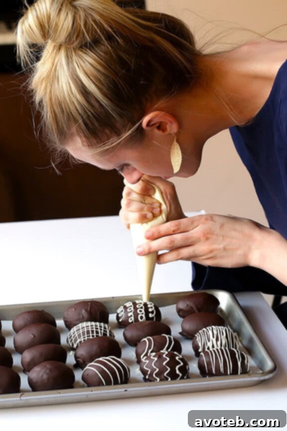 Elegant two-toned Easter Egg Oreo Truffles, drizzled with white chocolate for a sophisticated look.