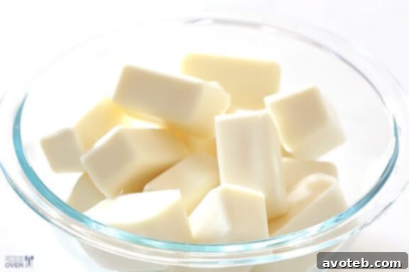 Dipping Golden Oreo Truffles in Melted White Almond Bark