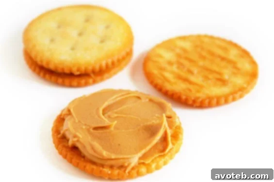 Close-up of a dipped Chocolate-Covered Ritz and Peanut Butter Cookie ready for setting.