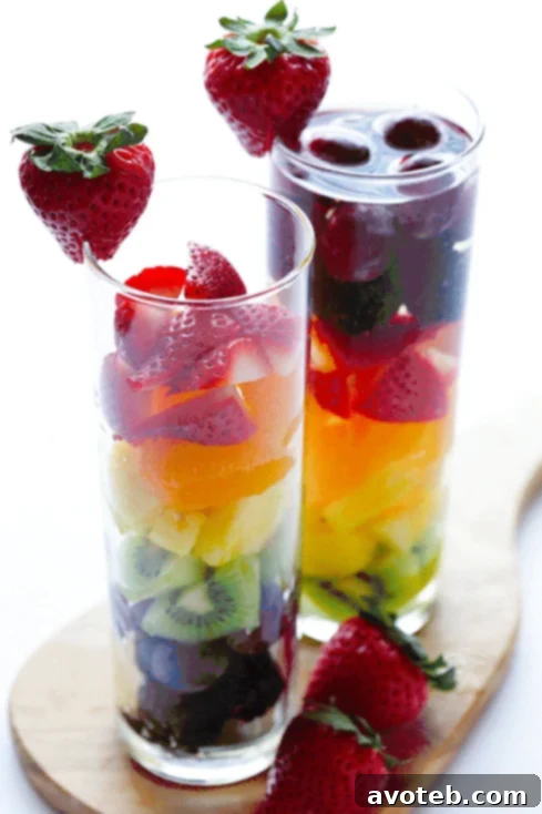 Close-up of Rainbow Sangria in a glass, showcasing layered colorful fruits.