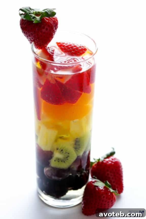 Overhead view of a pitcher and glasses filled with Rainbow Sangria, highlighting the fruit layers.