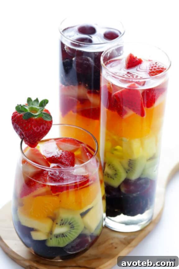 Rainbow Sangria with a spoon and straw, emphasizing edible fruit.