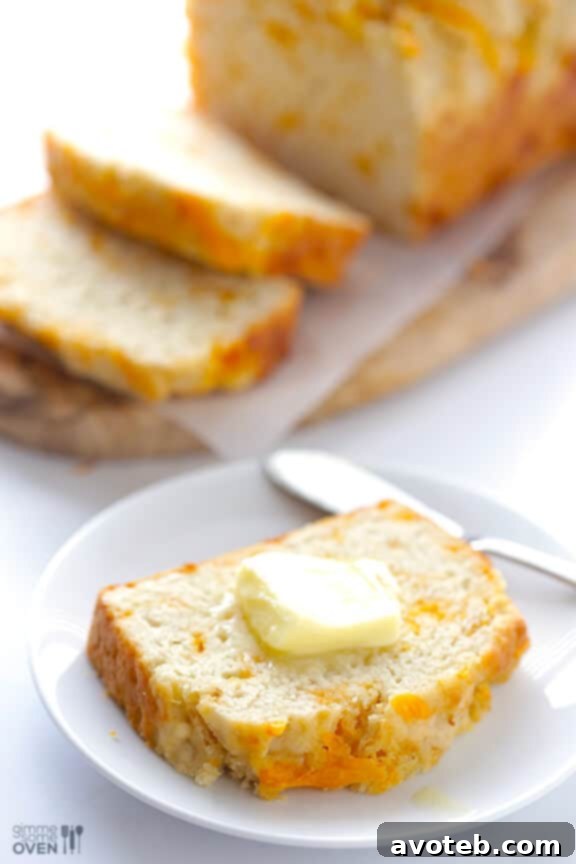 Garlic Cheddar Beer Bread sliced, revealing a moist, cheesy interior.