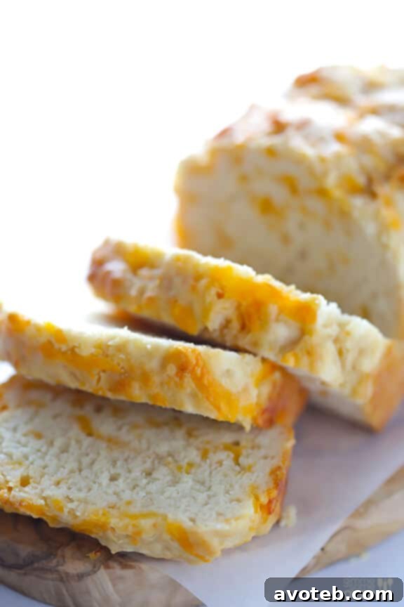 Close-up of a slice of Garlic Cheddar Beer Bread with a crunchy crust.