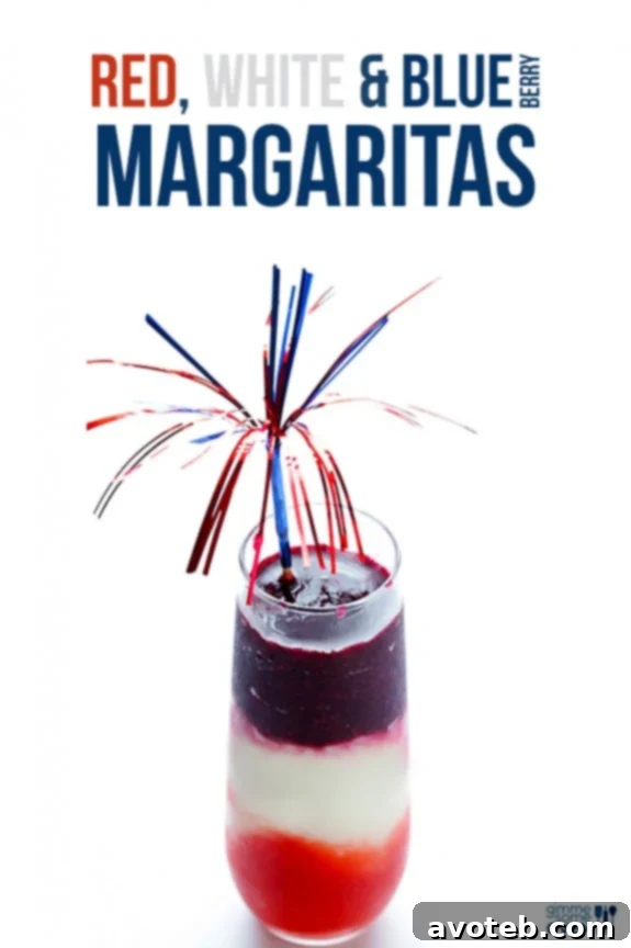 A top-down view of a Red, White & Blue(berry) Margarita in a frosted glass, adorned with a lime wedge, a colorful straw, and a small American flag pick. Perfect for summer parties.