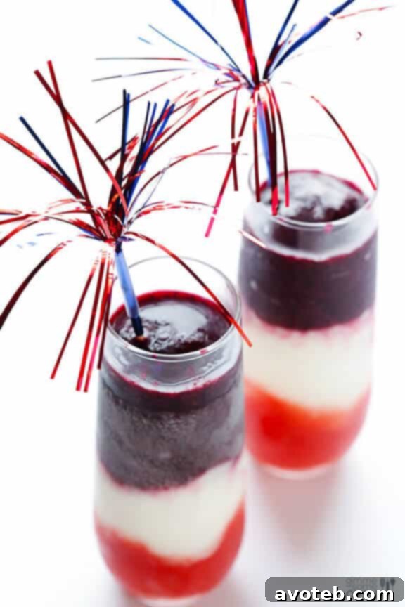 A Red, White & Blue(berry) Margarita in a salted-rim glass, adorned with a festive straw and a lime wedge, perfect for summer gatherings.