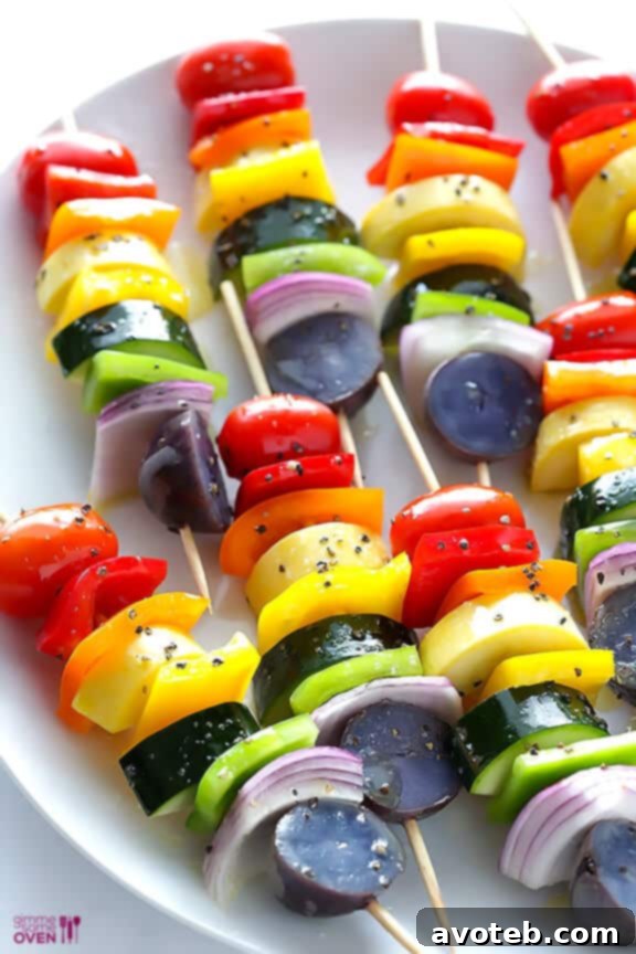 Chef grilling rainbow veggie skewers on an outdoor grill.