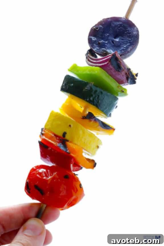 Freshly grilled rainbow veggie skewers on a plate.