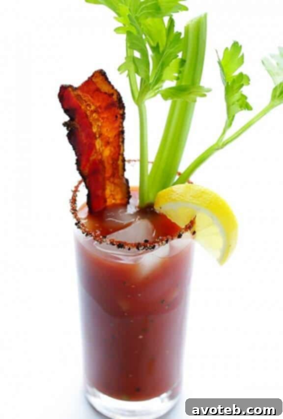 Delicious Peppered Bacon Bloody Mary cocktail with a crispy bacon strip garnish.