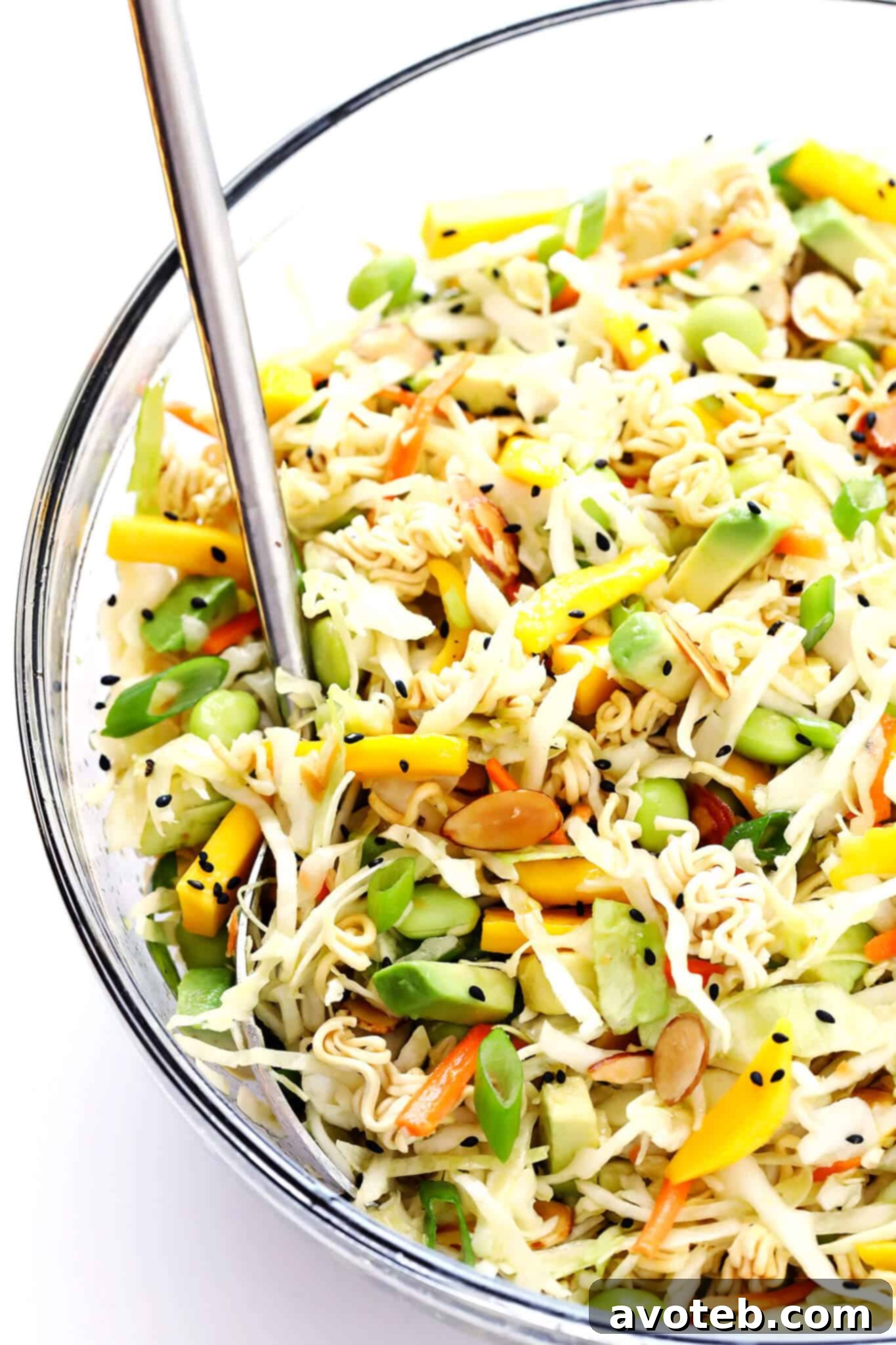 A large mixing bowl filled with the colorful Crunchy Ramen Noodle Salad, freshly tossed with the sesame vinaigrette and ready to be served.