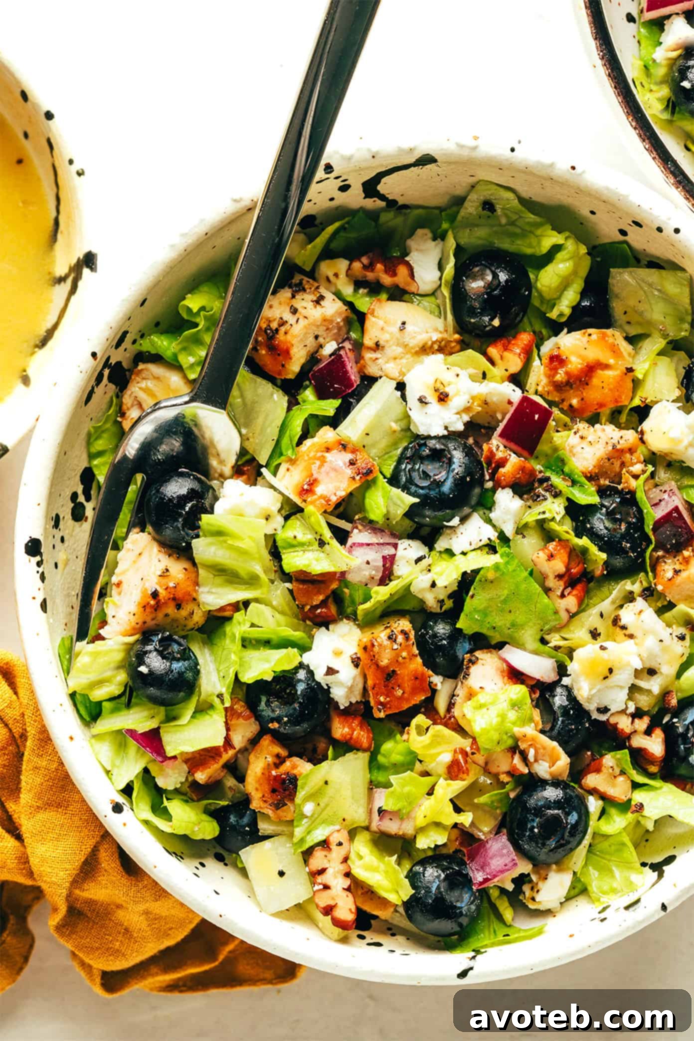 A close-up view of the Blueberry Chicken Chopped Salad, showing the texture of the chicken, the plump blueberries, and the chopped greens, with a focus on its appetizing appeal.