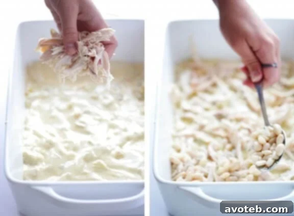 Layer of shredded chicken in the White Chicken Enchilada Casserole.