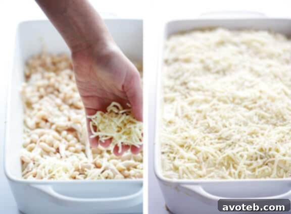 Adding shredded cheese to the White Chicken Enchilada Casserole layers.