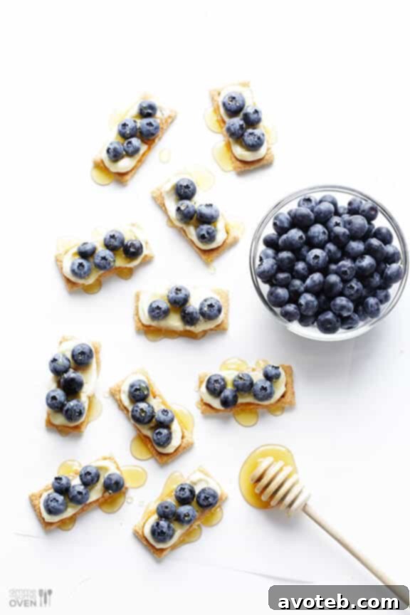 Adding fresh blueberries and honey drizzle to Laughing Cow graham cracker bites