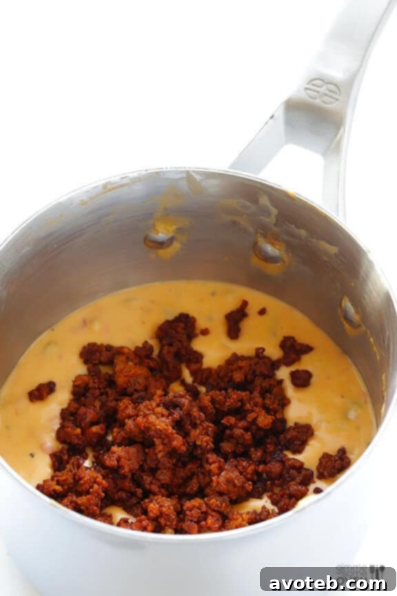 Melting Cheddar for Creamy Queso Creamy cheddar cheese melting into a smooth sauce for Chorizo Queso.