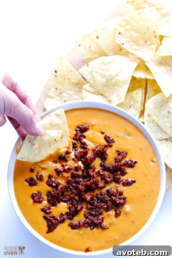 Mixing Chorizo into Queso Dip Chorizo being stirred into a rich, creamy queso dip, ready to be served.