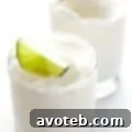 Close-up of a refreshing Coconut Margarita with lime and shredded coconut rim