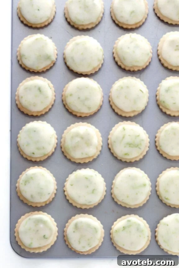 Tropical Coconut Lime Shortbread 5 Several glazed Coconut Lime Shortbread Cookies, with green lime zest sprinkled on top, ready to be enjoyed.