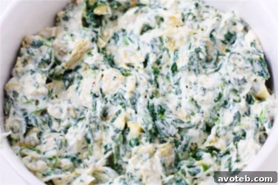 Close-up of baked Spinach and Artichoke Cups in a muffin tin, showcasing their golden-brown edges.