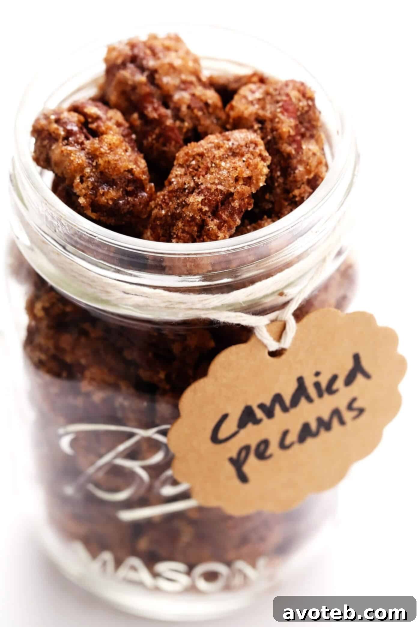 A mason jar filled with homemade candied pecans, ready to be given as a gift