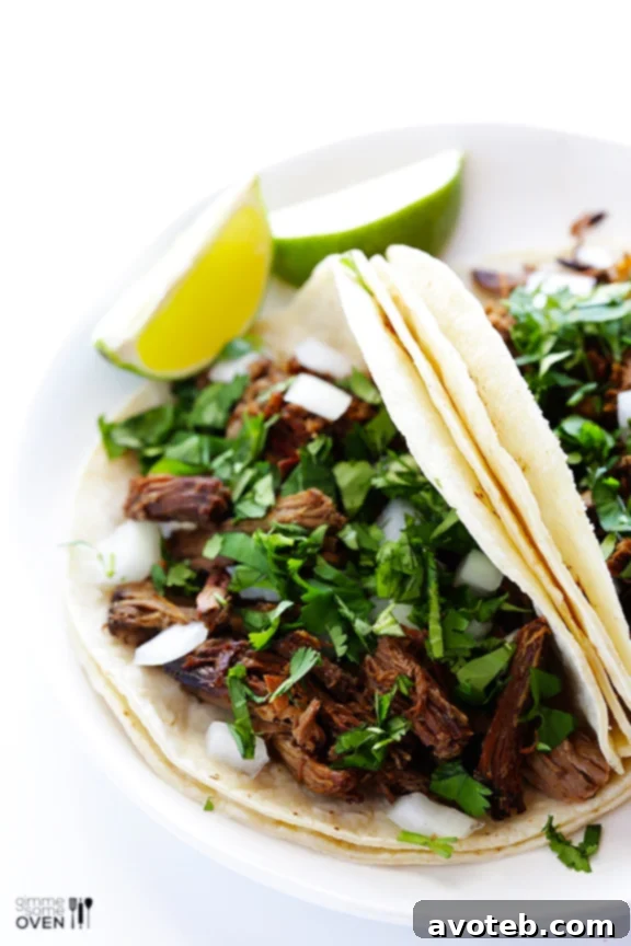 A delightful spread of barbacoa beef served with various accompaniments like tortillas, lime wedges, and salsa, inviting guests to create their own dishes.
