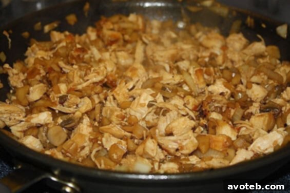Close-up of freshly prepared Chicken Lettuce Wraps with a savory filling and pouring sauce, ready to be enjoyed.