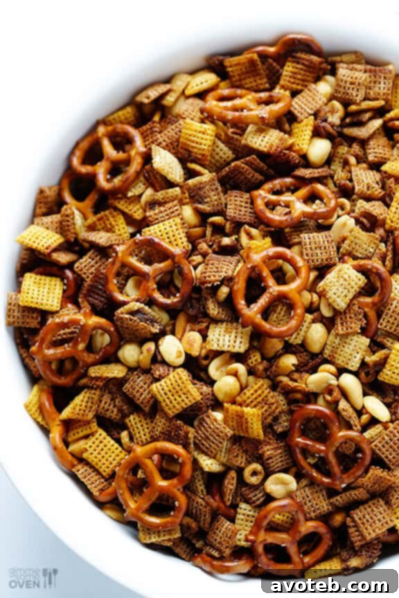 Effortless Slow Cooker Party Mix 8 Slow Cooker Chex Mix cooling on parchment paper.