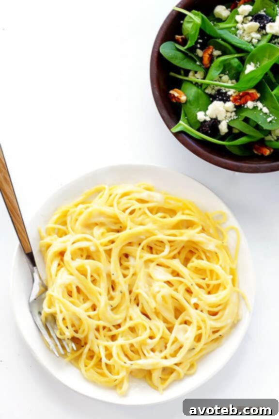 Tossing cooked pasta in the pan with Gluten-Free Alfredo Sauce before serving, ensuring every strand is coated in creamy, quick, and healthy goodness. | gimmesomeoven.com #glutenfree #gf