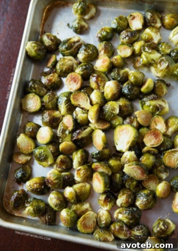 A rustic serving bowl filled with perfectly roasted Brussels sprouts, showing their inviting charred edges and infused with aromatic garlic, garnished with fresh herbs.
