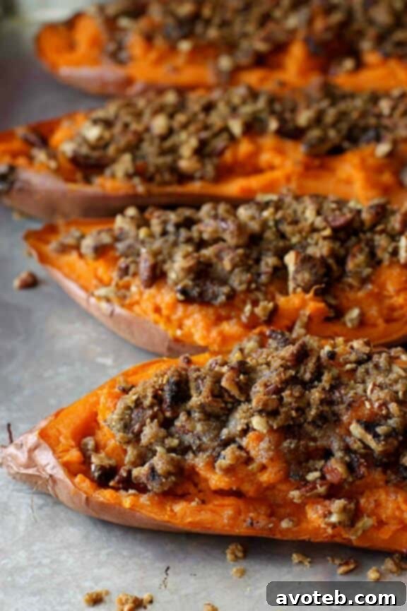 Several individual Twice-Baked Sweet Potatoes, topped with a flavorful, golden-brown chipotle pecan streusel, showcasing a perfect golden crust and inviting texture.