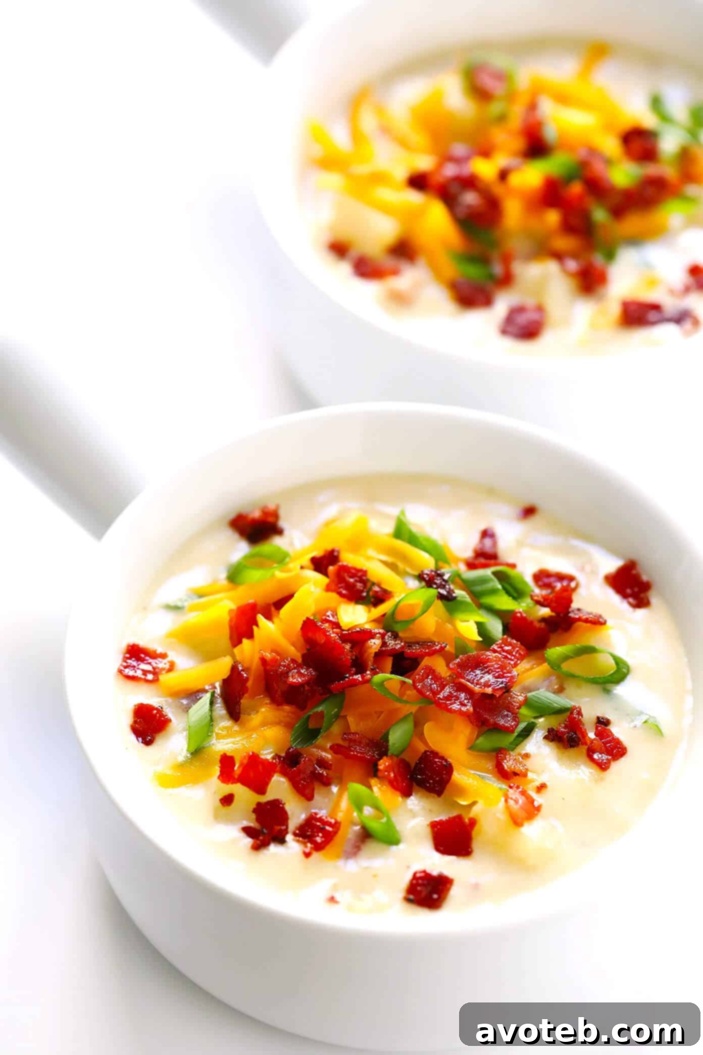 The BEST Potato Soup recipe! It's quick and easy to make, nice and creamy (with zero heavy cream), with lots of bacon (if you'd like). Total comfort food! | Gimme Some Oven #soup #potatosoup #dinner #bacon Homemade Potato Soup with Bacon and Cheddar in a bowl