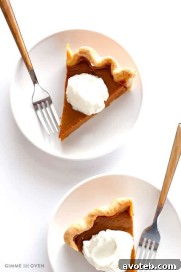 Bourbon Pumpkin Pie slice topped generously with bourbon whipped cream