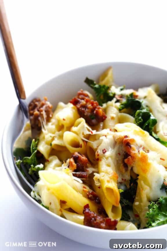 Close-up of baked ziti with melted cheese and kale, ready to be served.