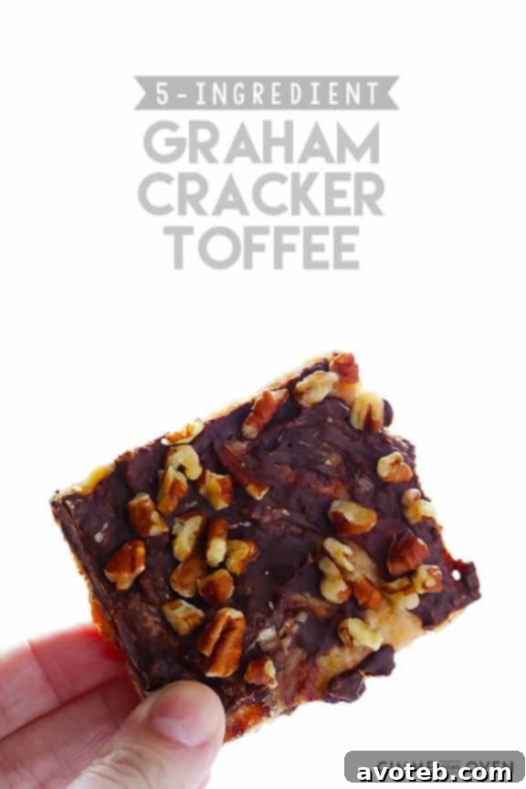 Close-up of a hand holding a piece of 5-Ingredient Graham Cracker Toffee, ready to eat