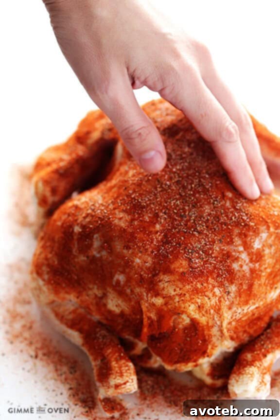 A whole, seasoned chicken ready to be placed into a slow cooker for an easy 'rotisserie' style meal.