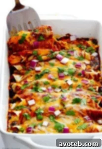 BBQ Chicken Enchiladas in a baking dish, garnished with fresh cilantro and red onion.