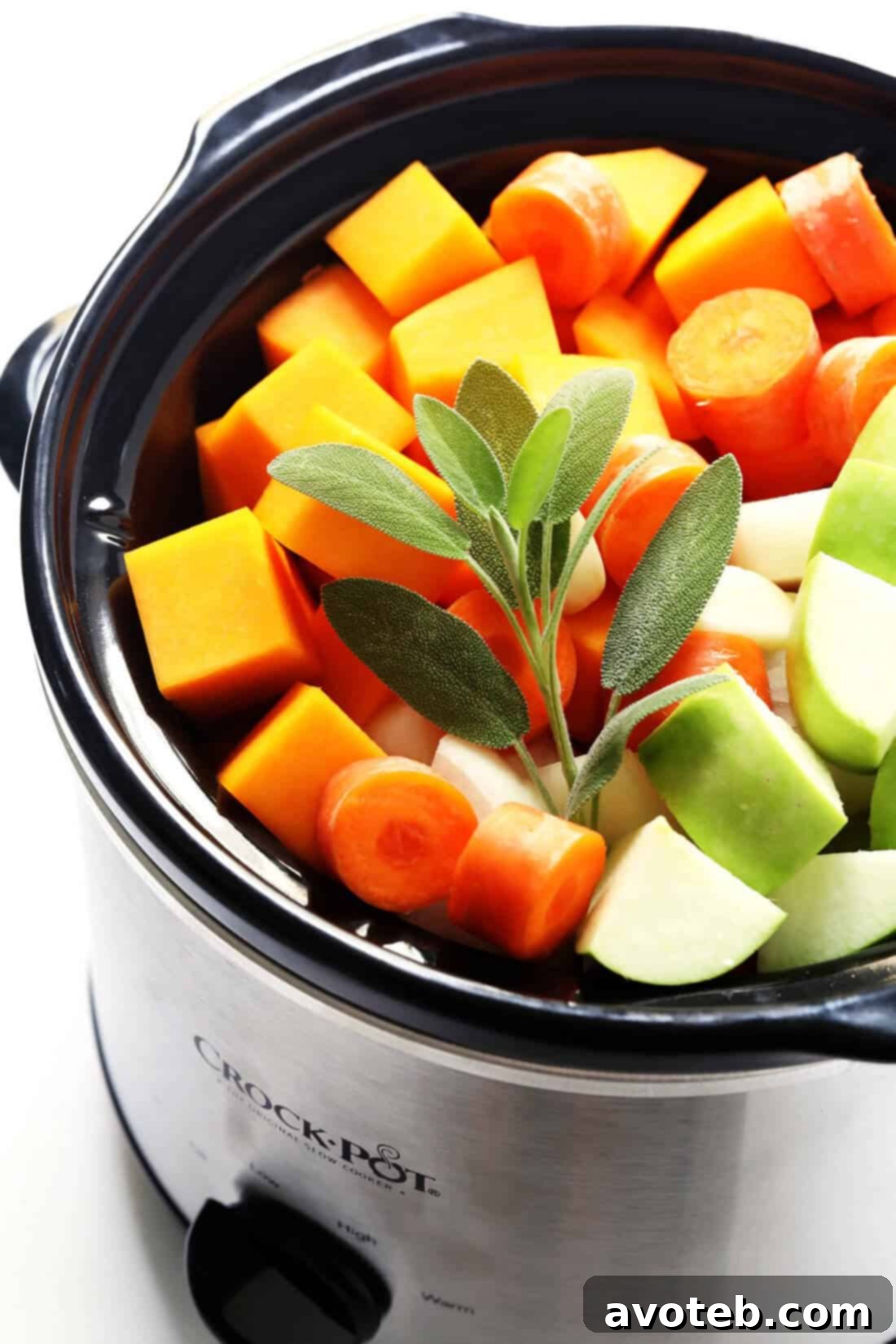 Fresh ingredients for Slow Cooker Butternut Squash Soup, including squash, carrots, onions, and spices.