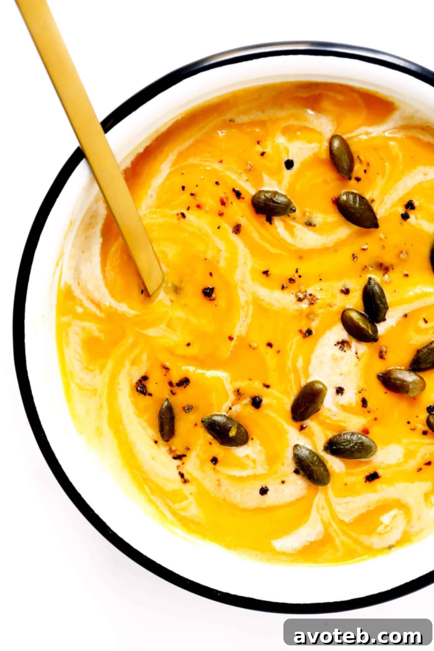 A beautifully garnished bowl of vegan butternut squash soup with pepitas.