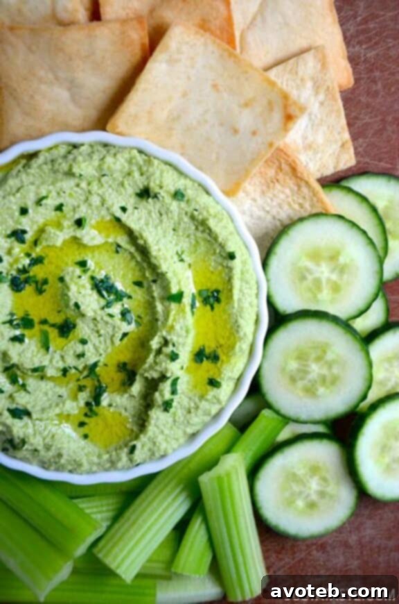 15 Recipes for Creamy Dreamy Hummus Bliss 4 A bowl of vibrant green Creamy Edamame and Pea Hummus, showcasing its smooth texture and fresh appearance, often garnished with fresh mint or pea shoots. This healthy dip is ideal for a light and refreshing snack.
