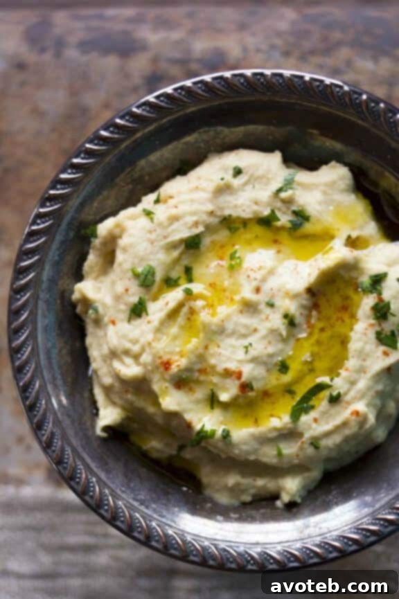 15 Recipes for Creamy Dreamy Hummus Bliss 8 A creamy bowl of perfectly smooth Roasted Garlic Hummus, elegantly garnished with a few roasted garlic cloves, fresh parsley, and a pool of olive oil. This classic offers a rich, mellow, and intensely flavorful experience.