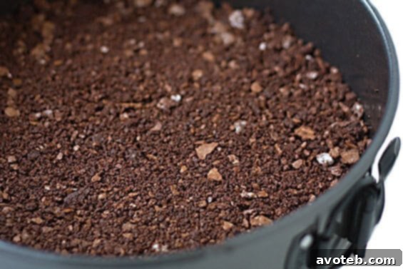Close-up of a slice of Bailey's Chocolate Cheesecake with ganache and chocolate shavings.