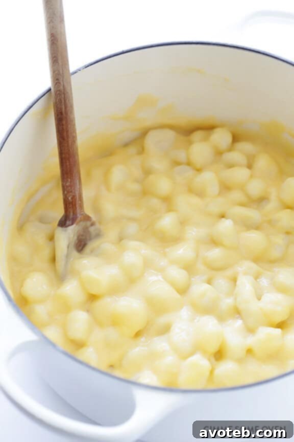 Gnocchi Cheese Gratin 8 Cooked gnocchi being tossed with the creamy cheese sauce