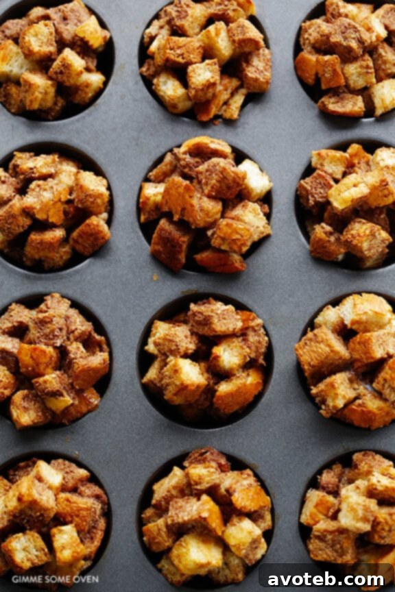 Step-by-step French Toast Cups recipe preparation: bread cubes soaking in a flavorful egg mixture in a mixing bowl